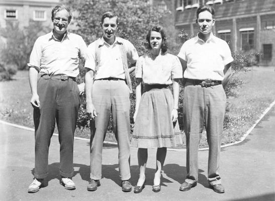 Men and a woman standing in front of a building, circa 1940