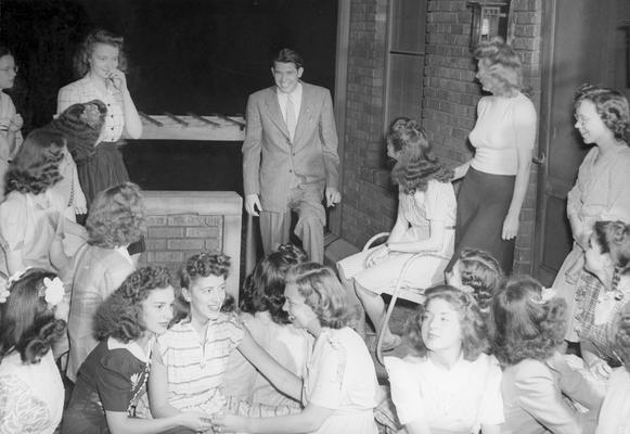 A group of women sitting outside while a man walks up the steps, possibly during RUSH