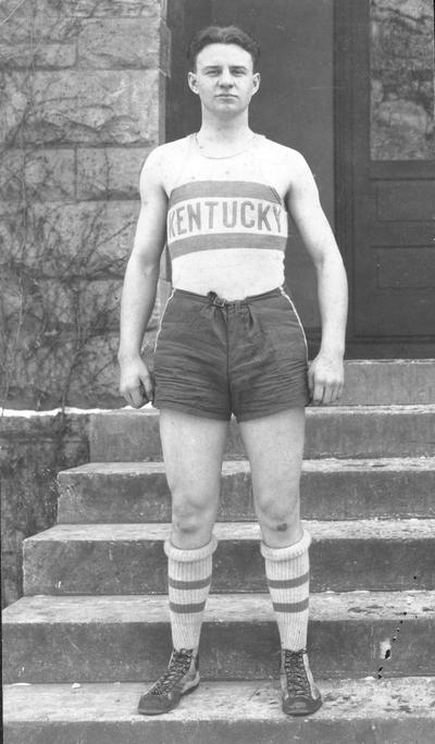 Basketball player, standing on steps outside a building, circa 1920