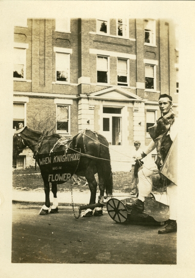 May 1930 A man dressed in costume with a horse wearing a sign: 