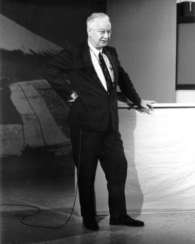 Man standing in studio, with microphone attached (Dr. George Brady, taught for WLEX-TV)