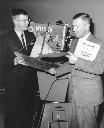 Student and teacher standing in front of WLEX-TV camera looking at wooden ship model, John P. Malick (Dr. Ellis Hartford)