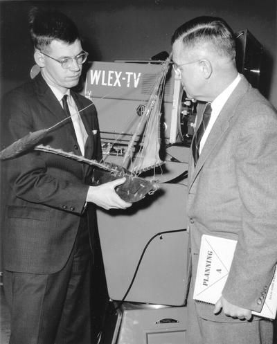 Student and teacher posed in front of WLEX-TV studio camera with model ship, John P. Malick (Dr. Ellis Hartford)