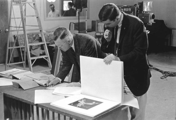 Two men looking through photos on WLEX-TV studio set (Dr. Ellis Hartford & Ronald Russell-Tutty)