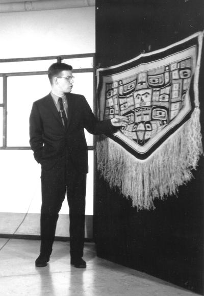 Dr. Doug Schwartz  standing at pre-Columbian tapestry