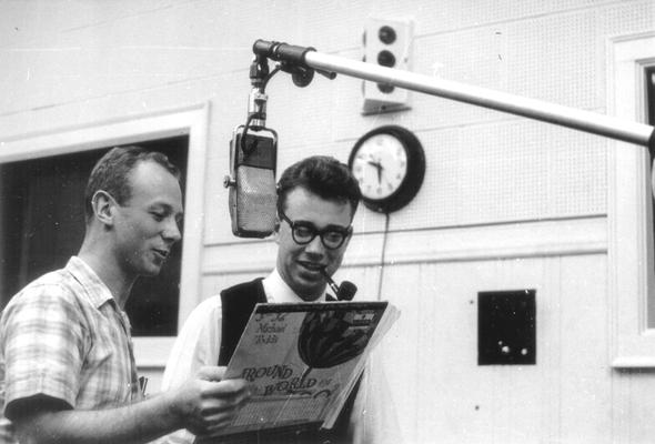 Two men reading the back cover of album: soundtrack to 