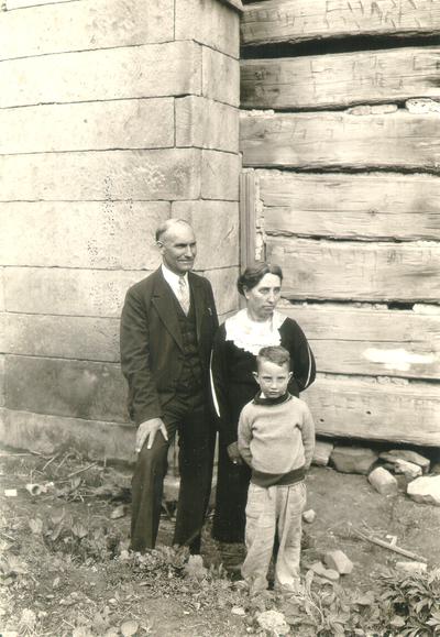 Man, woman, and child photographed next to large structure (same persons at center of #550): Letcher County, KY