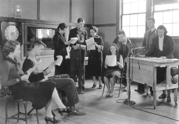 Young men and women reading scripts for radio theater in WHAS/UK studio; young woman, far right, using 