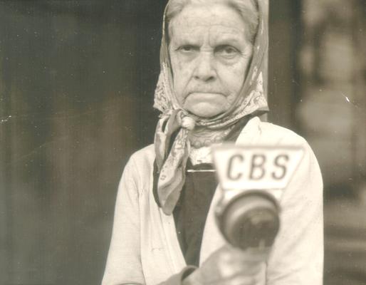 Same elderly woman as in #563, holding CBS microphone
