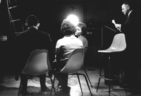 One male, two females, and professor in studio during taping of 