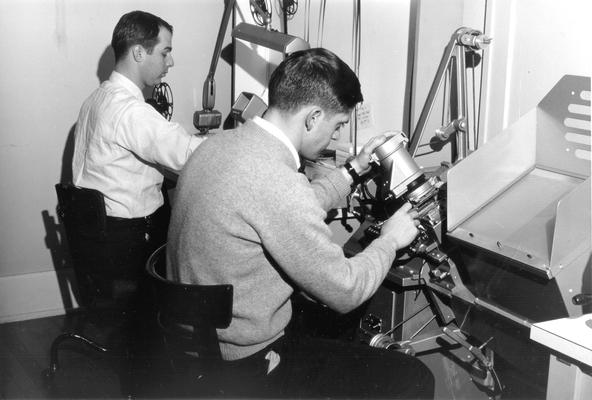 Two students working with film editing equipment