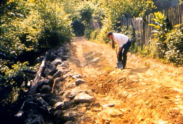 Man digging on muddy road