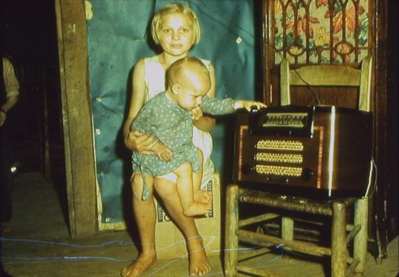 Young girl and baby sitting next to radio
