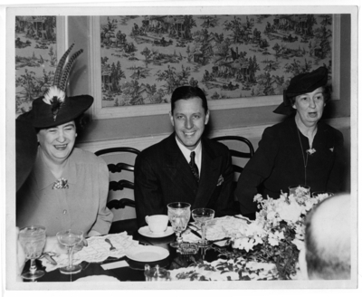 McLaughlin (far right) at a dinner table with two other unidentified, well dressed people to her right