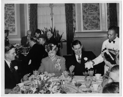 McLaughlin seated in the background, far left, (only half of her face is pictured) at the same dinner party as Item 3
