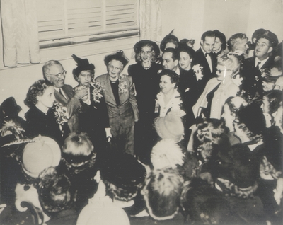Group of over twenty people in a room with Harry Truman and Bess Truman