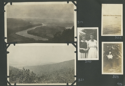 river cutting through the land; 2 women standing outside together; view of hills; water with a boat on it; a child standing next to a tree