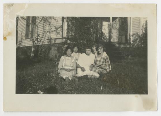 Five unidentified girls sitting in yard