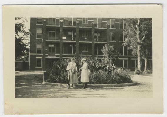 Two unidentified women standing in front of an unknown building