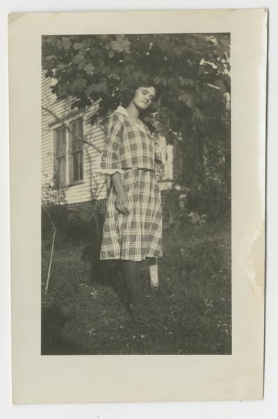 Unidentified young woman in yard
