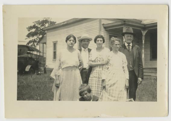 Six unidentified men and women in front of a house