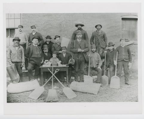 Group of men and small boy posing with shovels