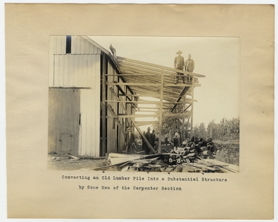 Converting an old lumber pile into a substantial structure by some men of the carpenter section