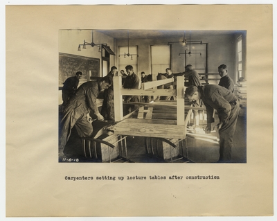 Carpenters setting up lecture tables after construction