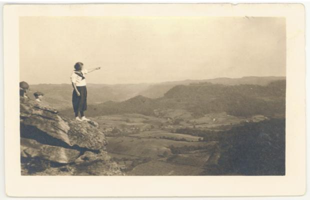 [Young Woman Pointing From East Pinnacle Toward Vista Below.] (Printed verso is Poem by C. Rexford Raymond, Dean of Religious Education, Berea College, titled 