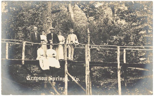 Grayson Springs. [Seven People Standing or Sitting On Pole Bridge]