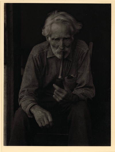 Nick Barton, Civil War veteran, d. May 1928.  Elderly, bearded man in polka-dot shirt, seated in chair, smoking