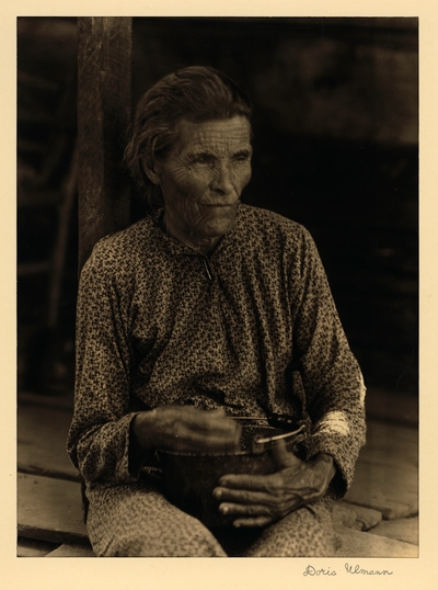 Mrs. Johnston; Singer; Brasstown, North Carolina.  Elderly woman seated on porch, holding pot.  Farmer's wife