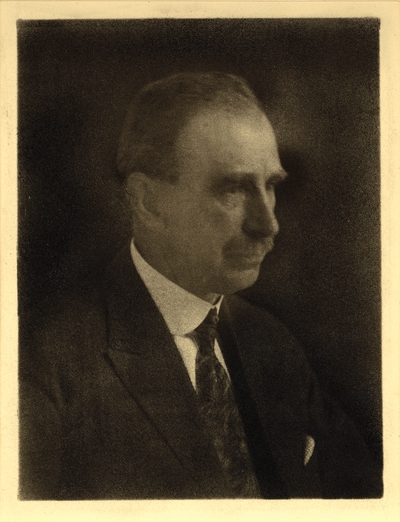 Head shot of man with mustache, in coat and tie