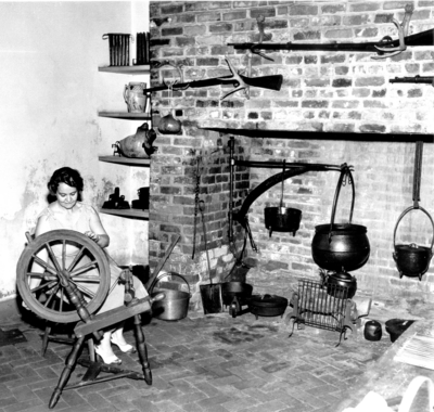 A variant print photograph by the Lexington Herald-Leader an interior view of the kitchen in the Ephraim McDowell House and an unidentified female. Reprints Sept 4  &  12 1952. 8x10 variant print