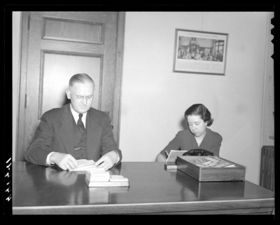 Deans & Professors (1940 Kentuckian) (University of                             Kentucky); man sitting at a desk, woman sitting besides the man taking                             notes (secretary)