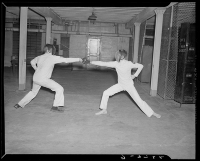 Fencing Team; interior of building, two fencing players                             engaged
