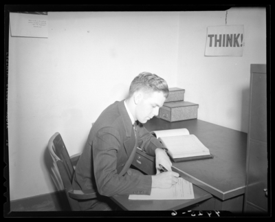 Man sitting at a desk, writing, (1940 Kentuckian) (University of                             Kentucky)
