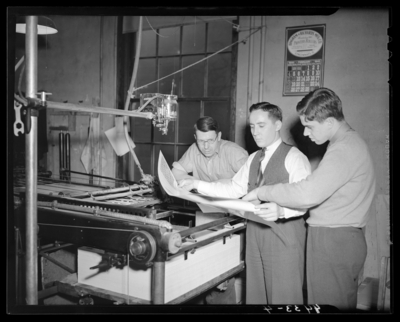 Print Shop, (1940 Kentuckian) (University of Kentucky); interior,                             three men standing next to printing press