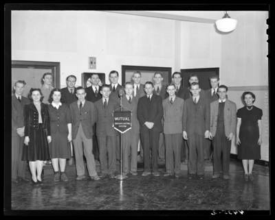 Radio Staff, (1940 Kentuckian) (University of Kentucky);interior,                             group of staff members standing in front of a microphone labeled                             