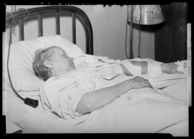 Mrs. Henry Baker; woman lying in bed, broken arm in a                             cast