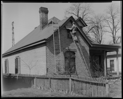 State Roofing and Siding Company; house at 154 London Avenue,                             exterior; man on ladder installing brick style siding