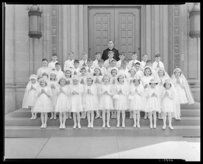 First Communion, St. Peter's Church; group of children and a                             priest standing in front of St. Peter's Church