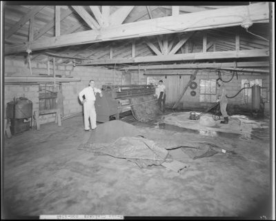 Drake Cleaners (120 Locust Avenue); interior of cleaning                             facility, two men operating cleaning machinery for rugs while one man                             leaning against cleaning machine