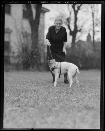 Mrs. March & dog (age 14); woman walking dog on lawn                             (grass)