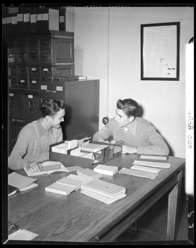 Campus Scenes, (1941 Kentuckian) (University of Kentucky); two                             men sitting at a table with card catalogs