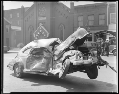Whaley automobile accident, two damaged (wrecked) cars; OK                             Service Garage (575 West Main), exterior; damaged (wrecked) car                             (vehicle) on tow truck hoist, 1941 Fayette County Kentucky license plate                             number M7053 (no. M7053)