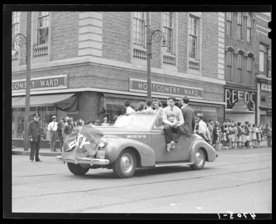 May Day Parade, (1941 Kentuckian) (University of Kentucky);                             students riding in a parade car down West Main; Montgomery Ward (300                             West Main) and Reeds (310 West Main) can be seen in the                             background