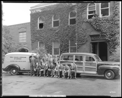 Public Service Commission; Mechanical Hall, University of                             Kentucky; exterior of building, group portrait of men sitting and                             standing in front of service vehicles (trucks)