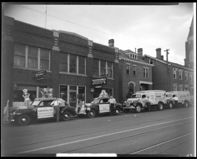 Walker-Megown Company (567-569 West Main); Kraft-Phoenix Cheese                             Corporation vehicles (trucks and cars) parked in front of buildings,                             vehicles decorated