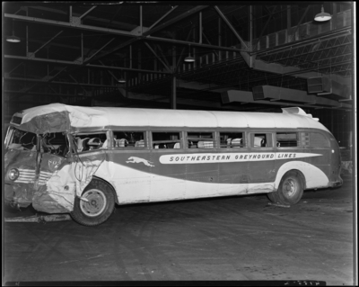 Southeastern Greyhound Lines; interior of garage; wrecked                             (damaged) bus number 803 (no. 803) (Columbia), side view